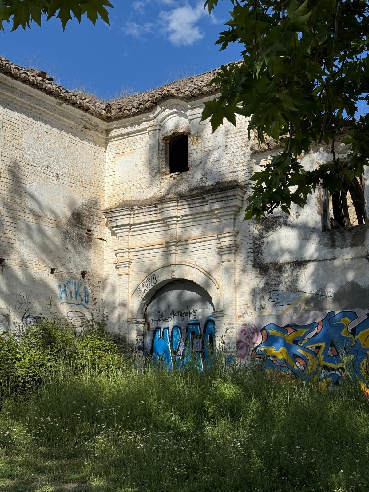 Portada barroca de ladrillo encalado con pintadas